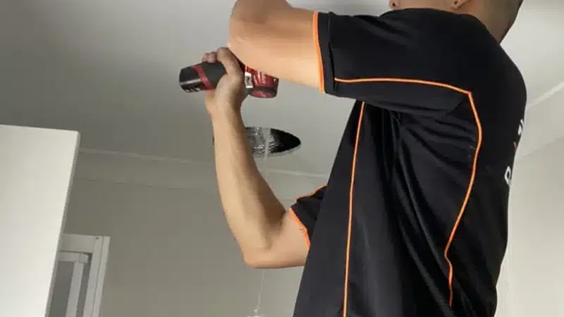 Powerhub electrician working on a ceiling fitting